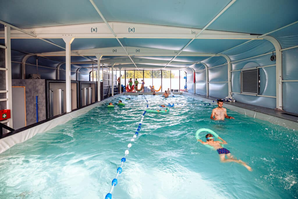 Binnenzwembad van Swimwise Club met kinderen en volwassenen tijdens zwemles en vrij zwemmen